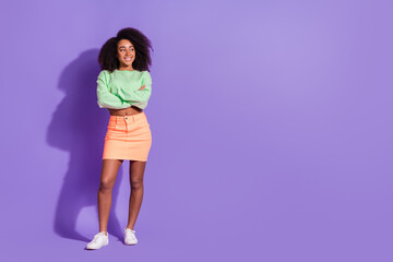 Full body length photo of young american girl wavy hair model folded hands look empty space isolated on violet color background