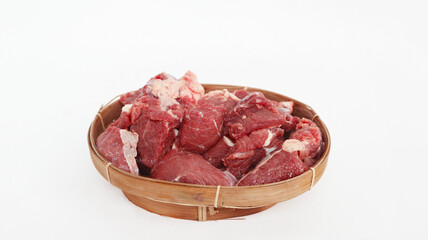 Beef raw meat on the Wicker bamboo baske on isolated white background. The feast of Qurban Ied al adha mubarak