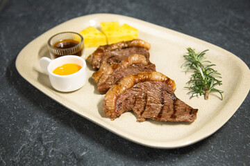 Juicy piece of grilled meat appetizingly displayed on a dark shale background