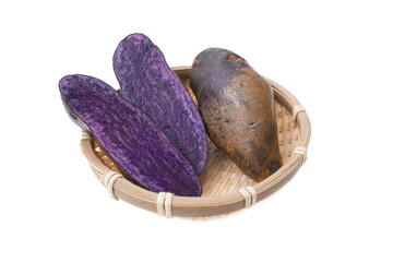 白バックでザルに並べたシャドークイーンという品種の紫ジャガイモ