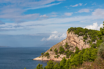 Breathtaking coastal vista featuring a rugged cliff rising dramatically from crystalline blue sea of Adriatic sea along Makarska Riviera coastline Split-Dalmatia, Croatia, Europe. Travel destination