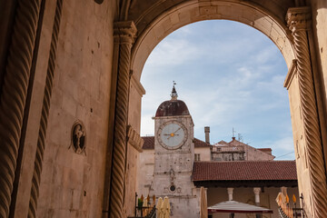 Picturesque arched doorway leading into charming town square with scenic view of iconic Clock Tower...