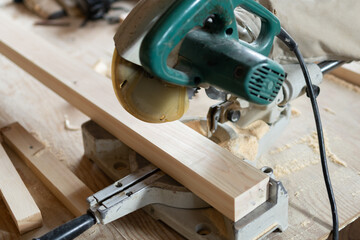 電気ノコギリで木材を切る