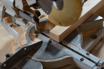 電気ノコギリで木材を切る