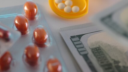 Counting money next to medicines and pills. Economic aspects of healthcare.