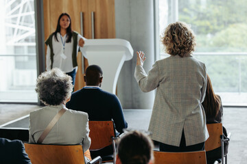 Business workshop with woman answering a question during formal presentation or talk
