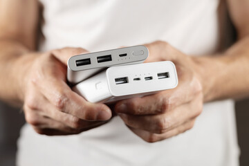 Two powerbanks in hand. Power bank for charging mobile devices.