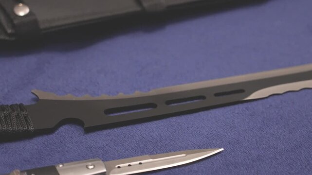 An illegal Zombie knife on a blue cloth. Part of some knifes that were bought online from an unregulated store - UK knife crime