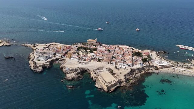 Aerial footage of Tabarca island, Spain. Clear sunny skies, blue waters, yachts in the bay. Calm sea, city and beach full of tourists. Popular Costa Brava location.