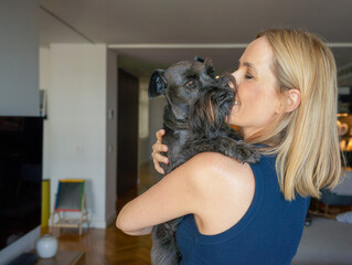 Portrait of a Young blonde woman hugging dog at home