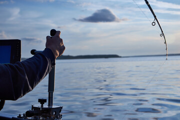 Obraz premium man drives a boat on the river on a summer day fishing