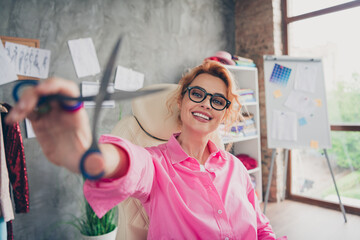 Portrait of nice young clothing designer lady scissors wear shirt loft interior office indoors