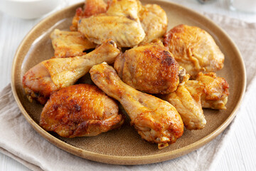 Homemade BBQ Chicken Drumsticks and Wings with Alabama White Sauce, side view.