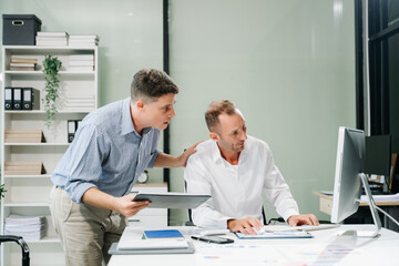 Two business workers talking on the smartphone and using laptop