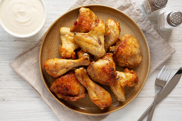 Homemade BBQ Chicken Drumsticks and Wings with Alabama White Sauce, top view.