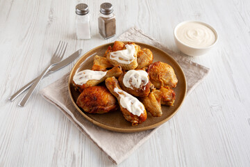 Homemade BBQ Chicken Drumsticks and Wings with Alabama White Sauce, side view.