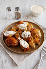 Homemade BBQ Chicken Drumsticks and Wings with Alabama White Sauce, side view.