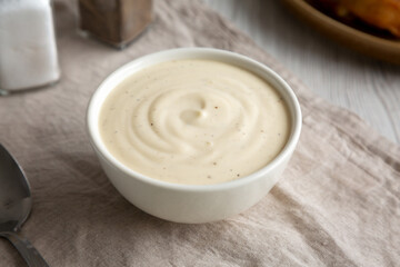 Homemade Alabama White Sauce for BBQ Chicken Drumsticks and Wings, side view.