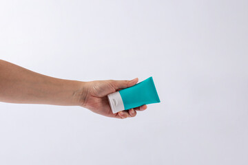 Obraz premium Blue cosmetic bottle, Skin care or sunscreen cosmetic in hand on white background.