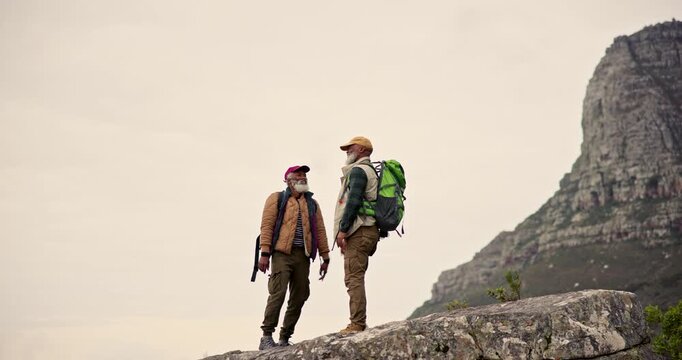 Men, friendship and high five on mountain for fitness goal, achievement and support. Mature people, teamwork and gesture in nature for success, wellness and journey together for solidarity or health
