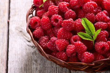 Raspberry in a basket .on wooden background