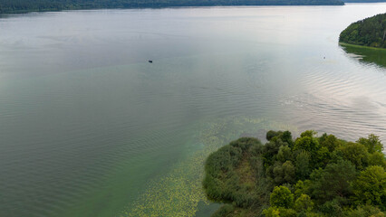 Drone photography of a boat in a lake and people fishing during summer day