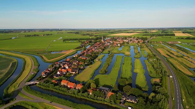 High angle Drone Point of View on the Village of Schermerhorn, Municipality of Alkmaar, North Holland, The Netherlands on summer evening in July, flying forwards