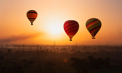 Many Hot air balloons floating over the Nile River in Luxor at sunrise