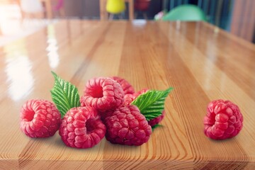 Tasty fresh ripe raspberries on desk