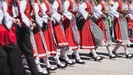 Abstract blurred people in traditional Bulgarian authentic folklore clothes dancing folk dance