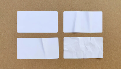 Blank white paper sticker label set isolated on cardboard background