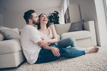 Photo of positive good mood couple dressed casual clothes hugging kissing having fun relaxing home indoors house apartment room