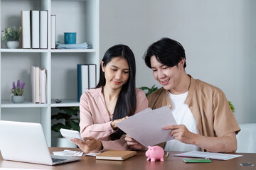 Young Couple Managing finance Together at Home with Laptop and Documents