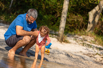 Fototapeta premium Young caucasian family having a picnic at the lake on a sunny afternoon.