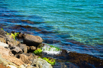 Scenic seascape with moss-covered rocks, waves on the shoreline, travel and nature background