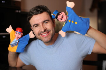 Guy holding some cute puppets 