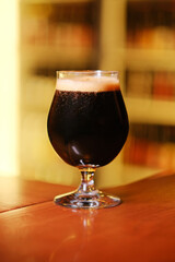 A glass of beer stands on the bar counter