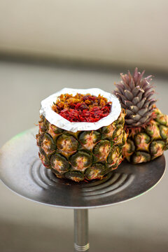 A hookah with a pineapple-shaped bowl, featuring an exotic and tropical design.
Un shisha con una cazoleta en forma de pi&ntilde;a, con un dise&ntilde;o ex&oacute;tico y tropical.