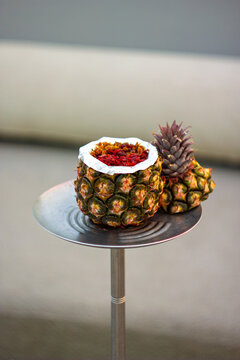 A hookah with a pineapple-shaped bowl, featuring an exotic and tropical design.
Un shisha con una cazoleta en forma de pi&ntilde;a, con un dise&ntilde;o ex&oacute;tico y tropical.