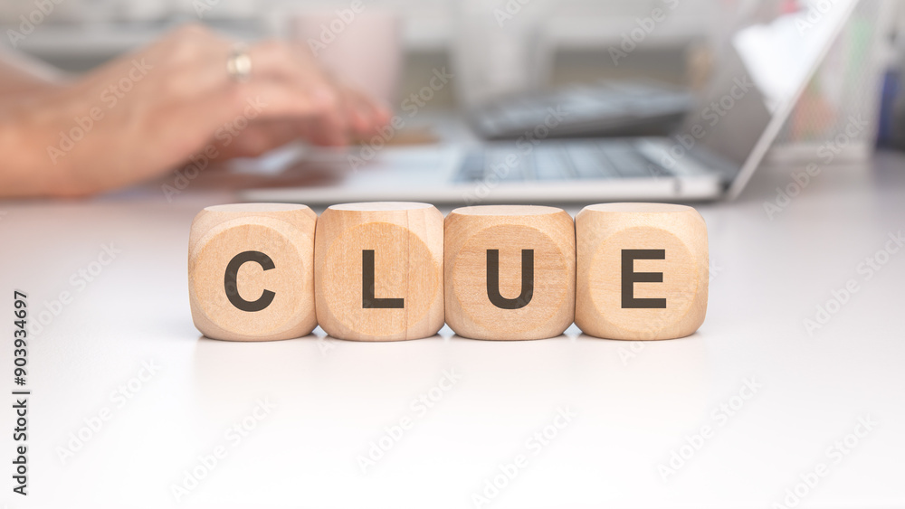 Poster clue blocks arranged on a desk surrounded by a background featuring a working laptop
