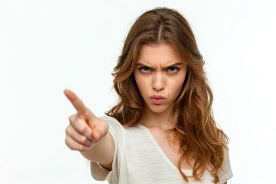 woman with angry expression looking at camera and pointing with index finger in accusatory way Isolated