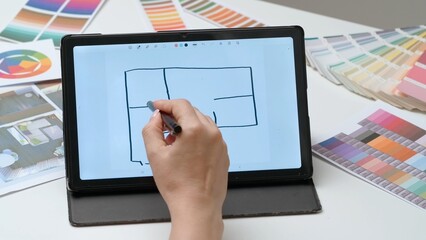 Woman architect home interior designer works on digital graphic tablet with stylus, hand draws new apartment project. Creativity and modern technology