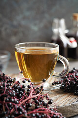 A cup of tea with black elderberry syrup with copy space
