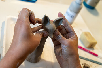 shape clay with hands	