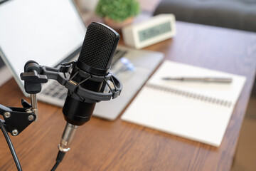 Concept of podcast, broadcasting or recording home studio with microphone and notebook or laptop.