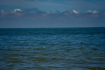 Obraz premium a lonely sailing ship at sea against a blue sky