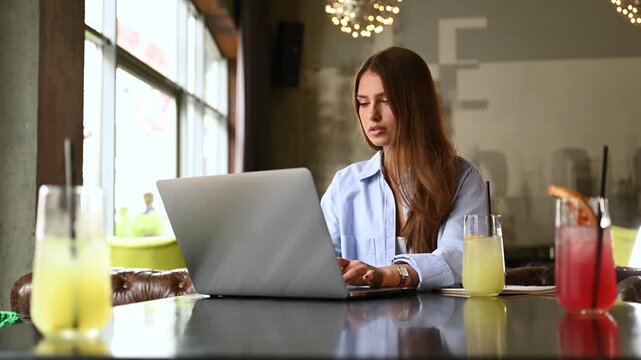 Caucasian freelancer making online webinar translation during remote working in street cafe, skilled female graphic designer with laptop computer communicate during video calling on netbook