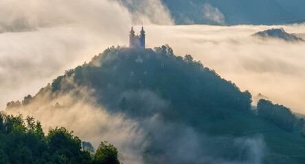 Natural scenery with fog and a historical building obscured in the fog. Beautiful natural view, wet...