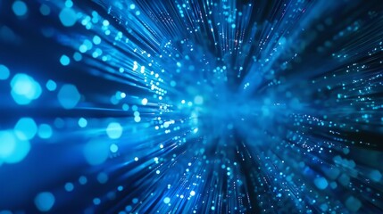 Fototapeta premium Abstract blue fiber optic light beams radiating in a dark background illustrating data communication.