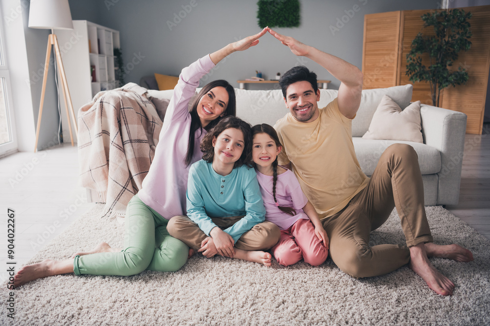 Sticker Photo of positive good mood parents children dressed casual clothes showing arms roof indoors house apartment room